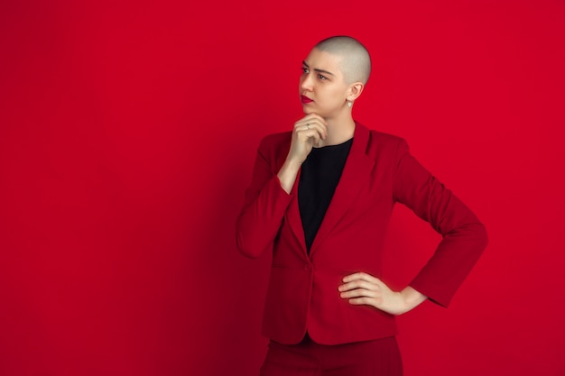 Portrait of young woman with freaky appearance on red wall