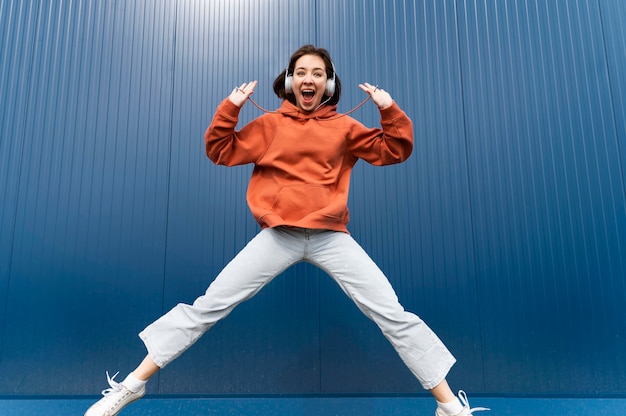 Free Photo portrait young woman with headphones jumping