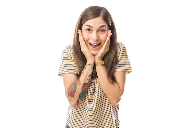 Portrait of young woman with mouth open looking surprised on white background