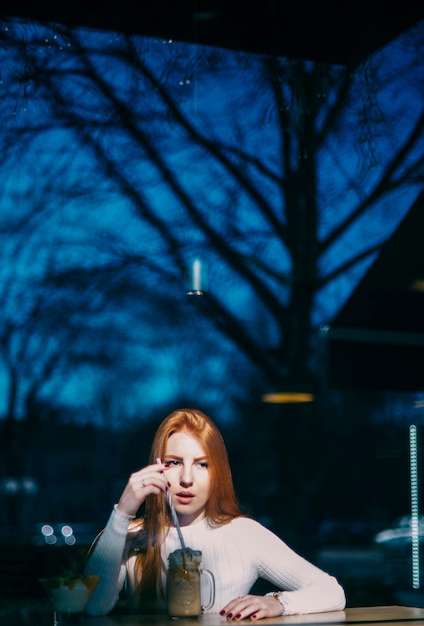 Free photo portrait of a young woman with smoothie jar in caf�