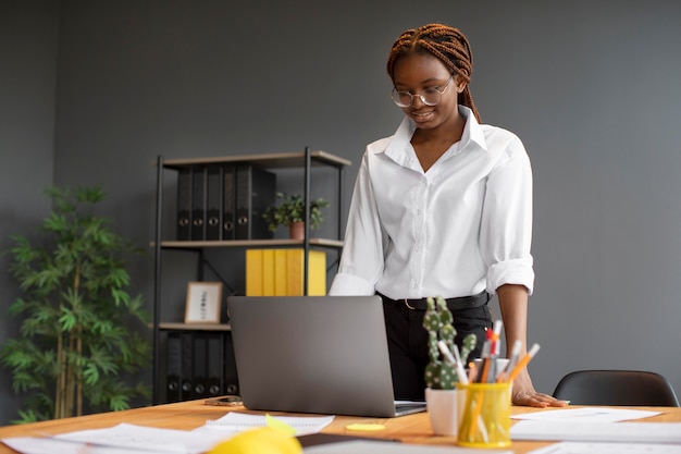 Portrait of young woman working on her laptop at a startup company