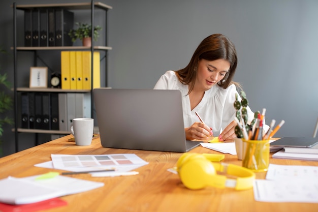 Free photo portrait of young woman working on her laptop at a startup company