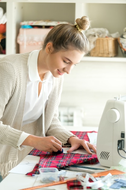 Free photo portrait of a young woman working with a sewing pattern