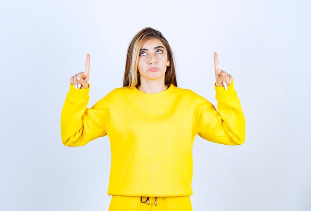 Portrait of young woman in yellow outfit posing to camera