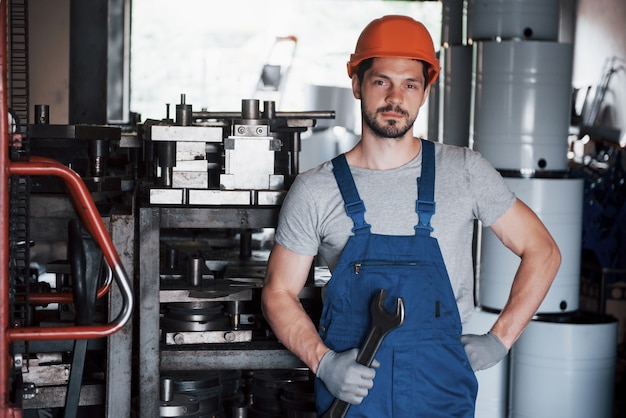 Free photo portrait of a young worker in a hard hat at a large metalworking plant.