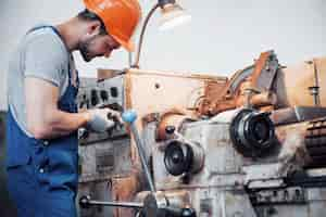 Free photo portrait of a young worker in a hard hat at a large metalworking plant.