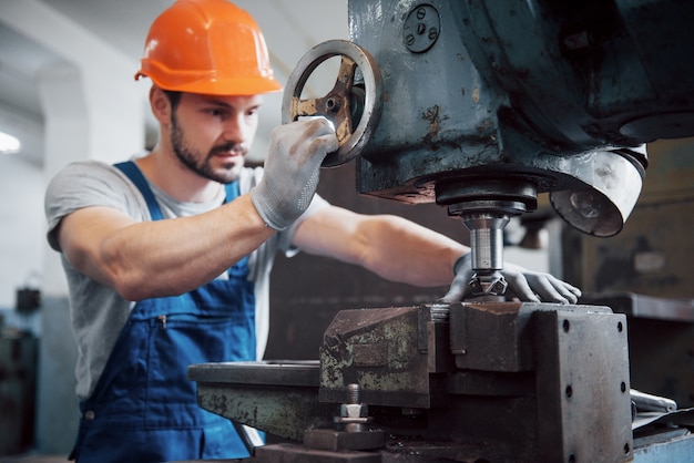 Free photo portrait of a young worker in a hard hat at a large metalworking plant.