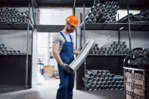 Free photo portrait of a young worker in a hard hat at a large metalworking plant.