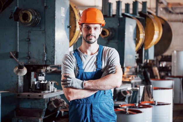 Free photo portrait of a young worker in a hard hat at a large metalworking plant.