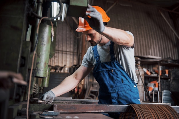 Free photo portrait of a young worker in a hard hat at a large metalworking plant.