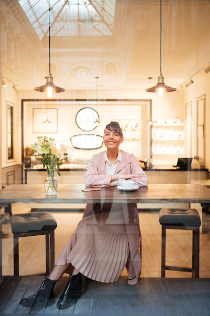 Free photo portrait of a young young woman sitting at the modern cafe