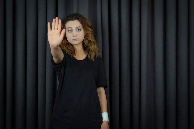 Portraits of depressed young girl putting her hand to the camera and gesture to stop. High quality photo