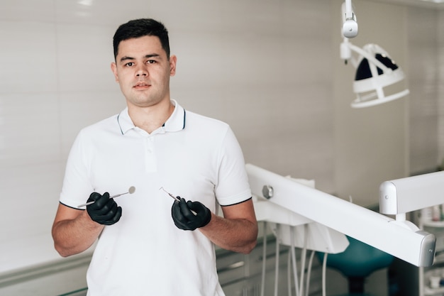 Posing dentist holding equipment