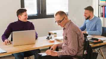 Free photo positive adult men working together at the office