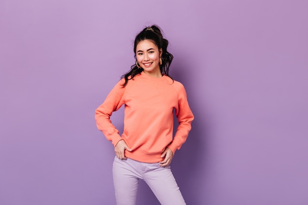 Free photo positive asian woman standing with hands on hips. confident japanese young woman smiling at camera.