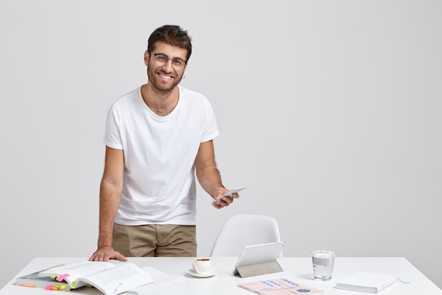 Positive attractive unshaven male works on news report