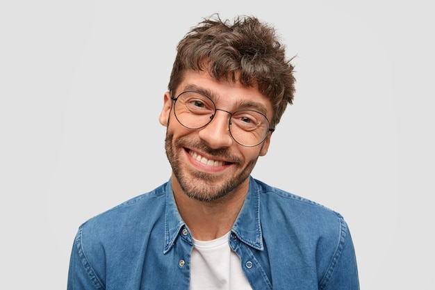 Free photo positive bearded man with friendly smile, being in high spirit as spends free time