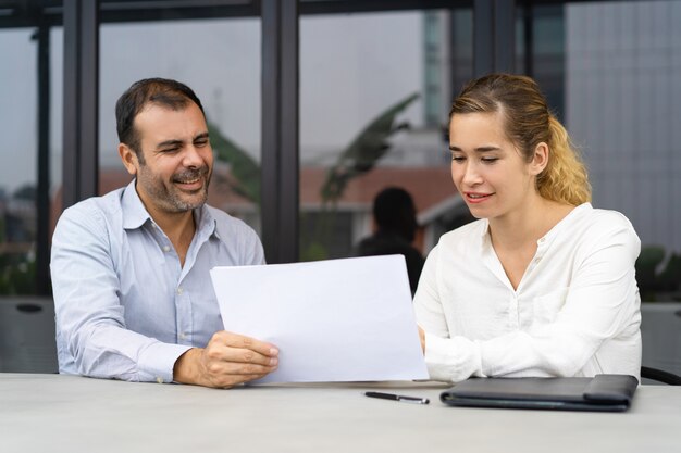 Positive businessman asking expert to check documents