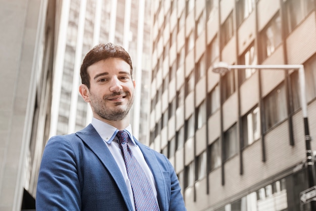 Free photo positive businessman standing on street