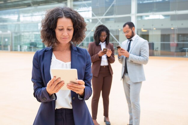 Positive businesswoman watching content on tablet