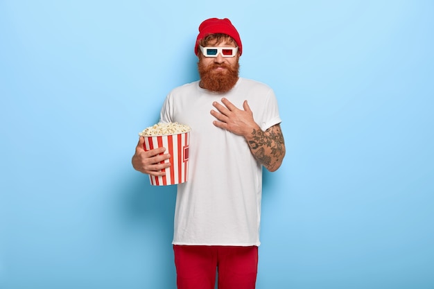 Free Photo positive carefree young man with ginger beard, touches chest