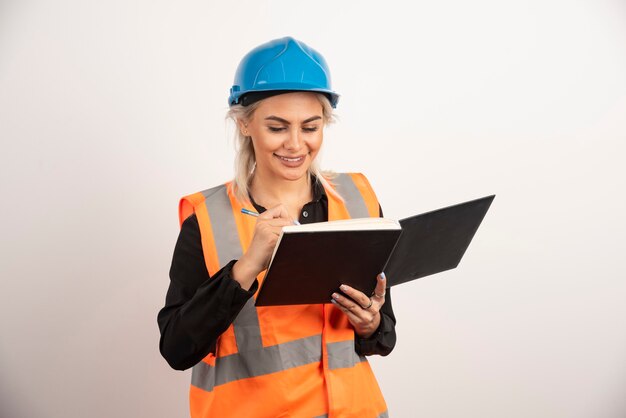 Positive construction worker writing in notebook. High quality photo