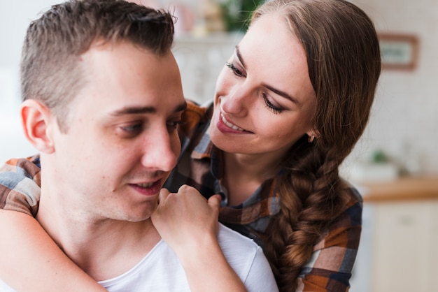 Positive couple hugging at home