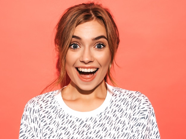 Free Photo positive female smiling. funny model posing near pink wall in studio.shocked and surprised