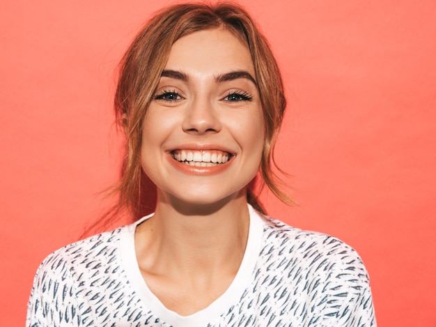 Positive female smiling. Funny model posing near pink wall in studio