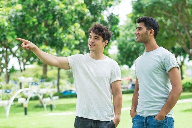 Positive friendly guy showing direction to Indian man