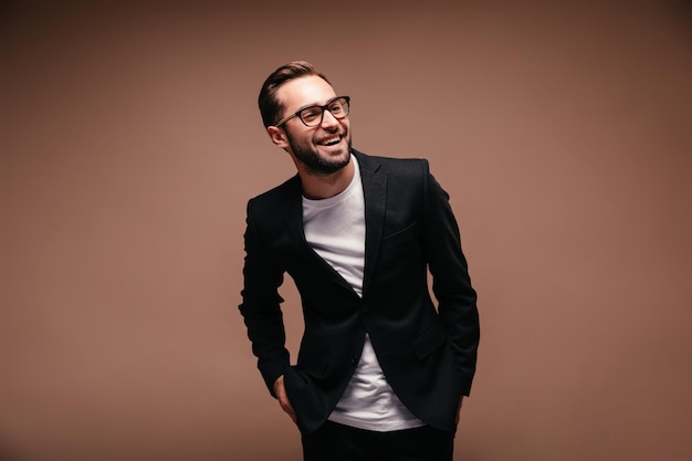 Free Photo positive guy in black suit and white tshirt is smiling on isolated background