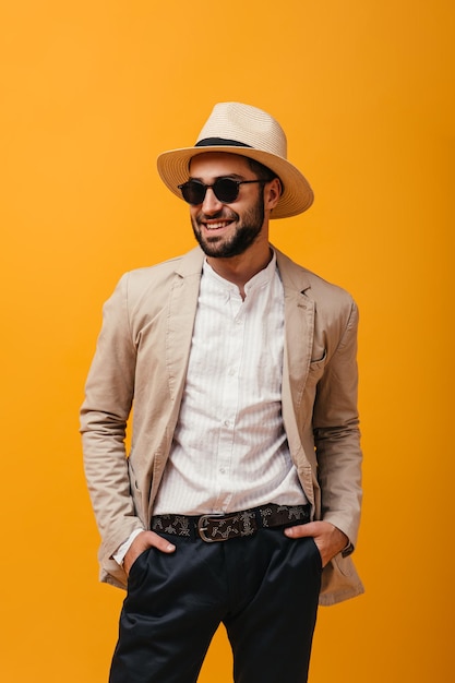 Free photo positive guy in hat and sunglasses smiling on isolated background