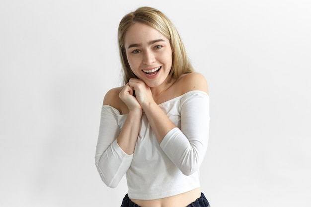 Positive human reaction, feelings, attitude and emotions. Picture of adorable excited young fashionable woman expressing joy and amazement, fascinated with good news, being finally promoted at work