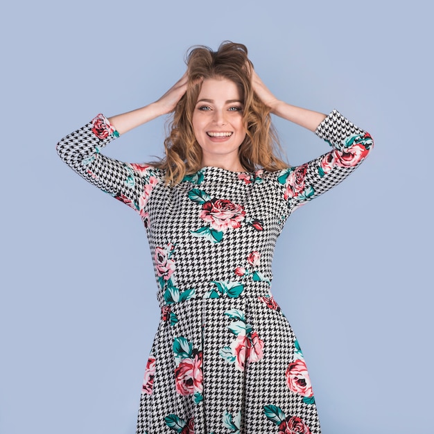 Positive passionate woman in dress with hands on hair