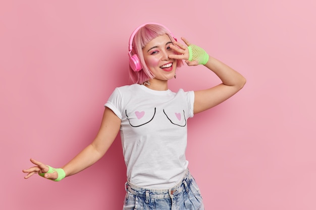 Free Photo positive upbeat asian teenage girl feels carefree moves with rhythm of music