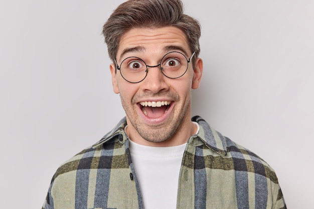 Free Photo positive young adult man reacts on something awesome feels very glad dressed in casual clothes isolated over white background expresses amazement being pleasantly shocked. human reaction concept