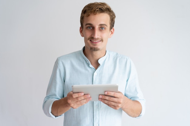 Free Photo positive young man holding tablet computer