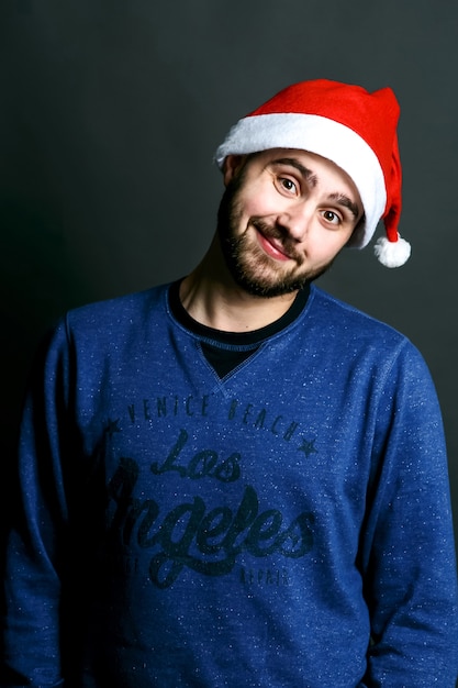 Free photo positive young man in red christmas hat