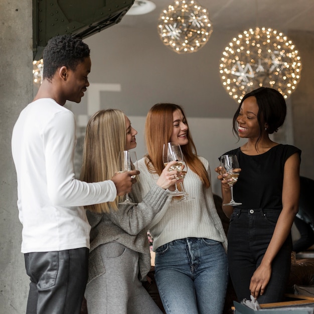 Free photo positive young people having wine together