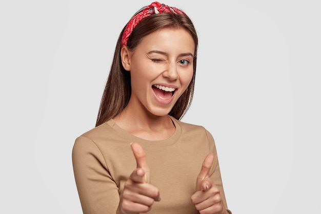 Positive young student posing against the white wall