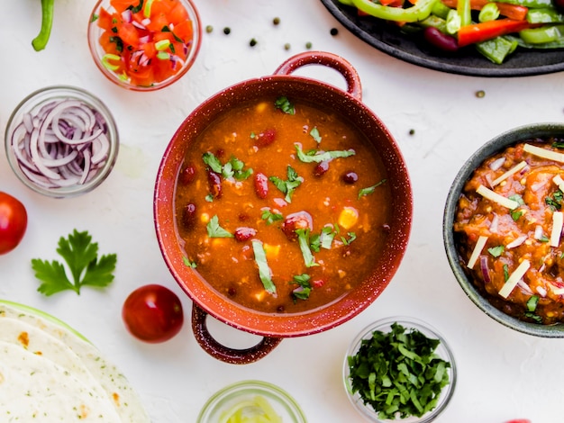 Pot of chili next to Mexican snacks