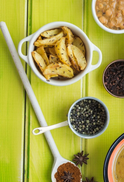 Free photo pot with fried potatoes near spices