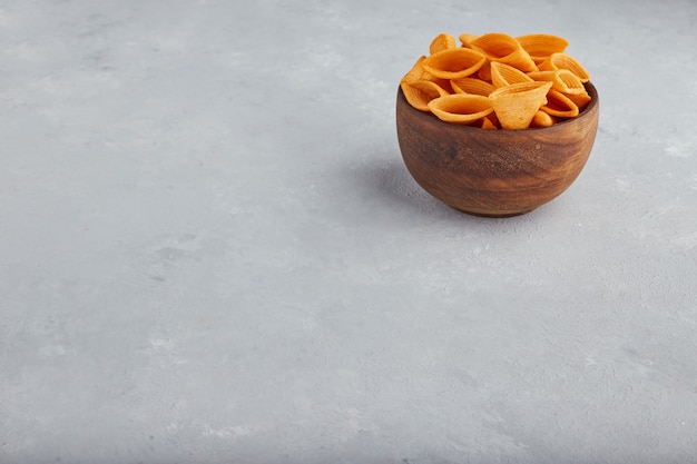 Free photo potato chips in wooden bowl in the top corner.