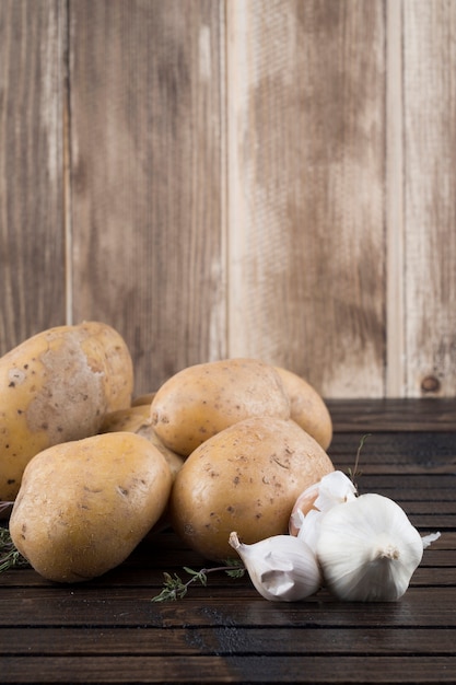 Potato and garlic on wooden table