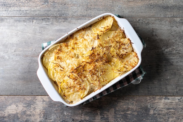 Potato gratin baked with cream and cheese on wooden table Close up