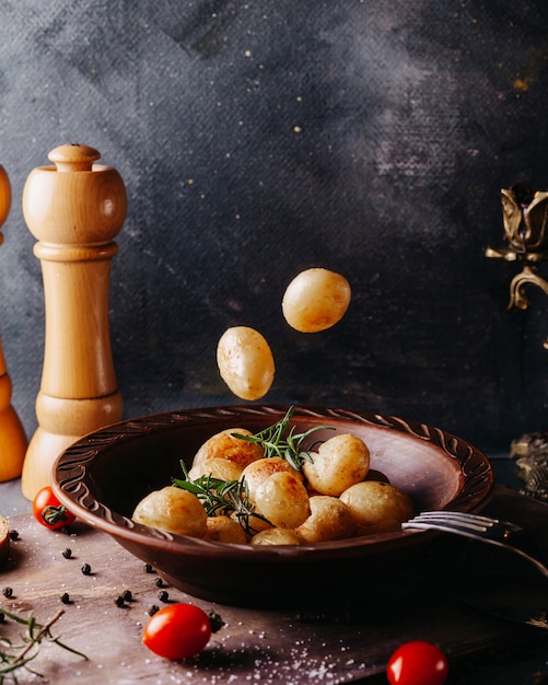 Potatoes boiled salted inside brown round plate on the grey surface