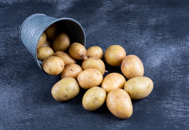 Free photo potatoes in a bucket high angle view on a dark table