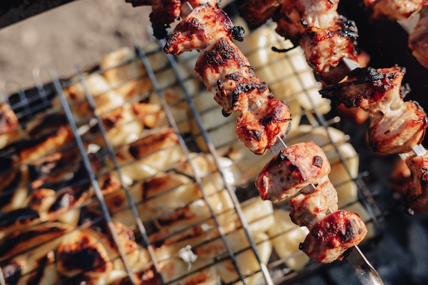 Potatoes and grilled meat. fire and heat. cooking in nature.