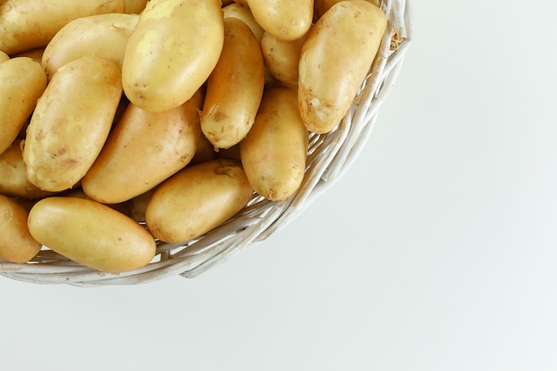 Free photo potatoes in a wicker basket on white table, flat lay.