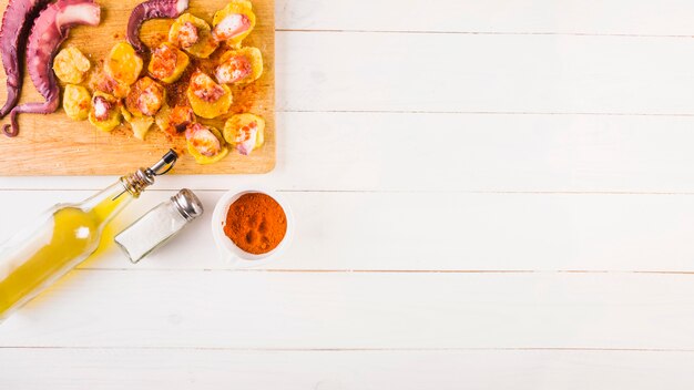 Potatoes with octopus on cooking desktop